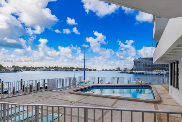 view of swimming pool with a water view and a patio