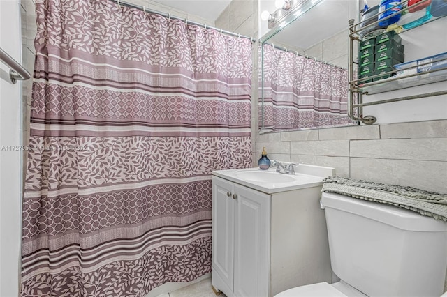 bathroom with toilet, vanity, tile walls, and decorative backsplash