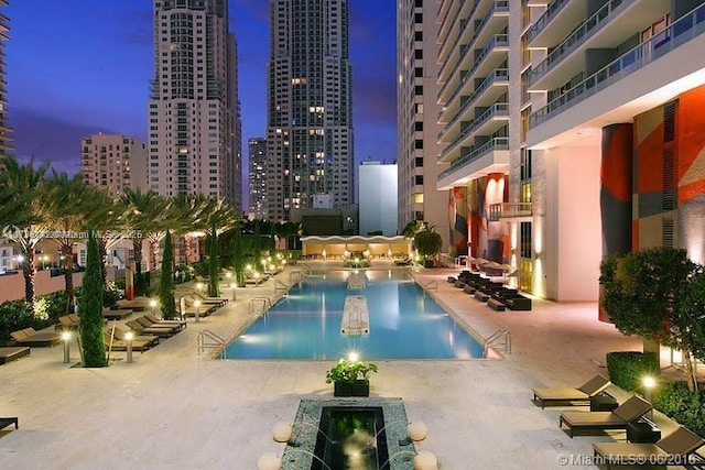 pool at dusk with a patio