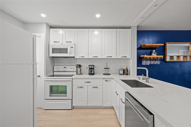 1400 NE 191st St Unit 307, Miami, FL 33179 - kitchen with white appliances, a sink, recessed lighting, white cabinets, and light wood-style floors