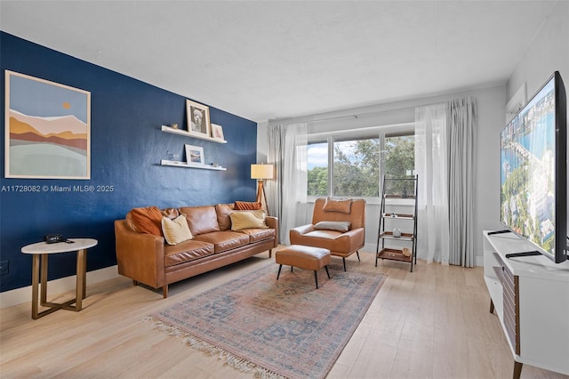1400 NE 191st St Unit 307, Miami, FL 33179 - living area featuring light wood-type flooring and an accent wall