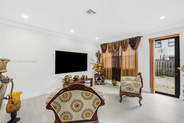 living room featuring crown molding and light hardwood / wood-style floors