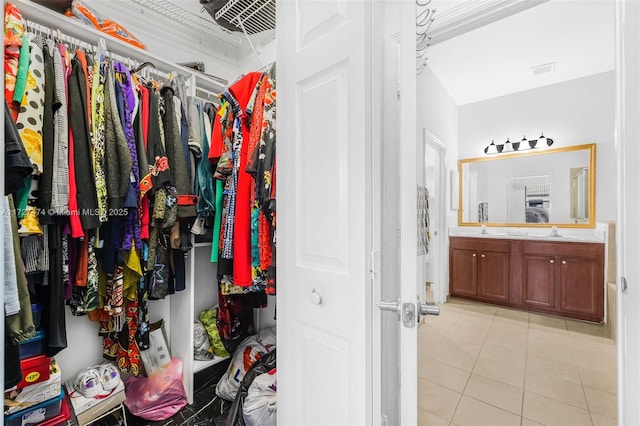 walk in closet featuring sink and light tile patterned floors