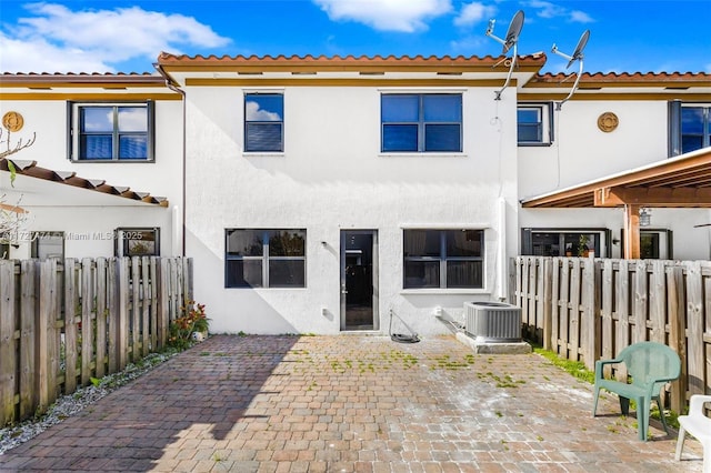 rear view of property with cooling unit and a patio area