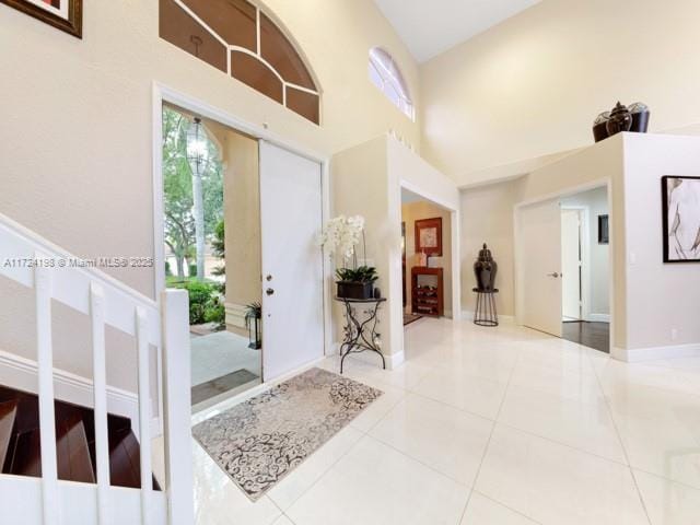 entryway with a high ceiling and tile patterned floors