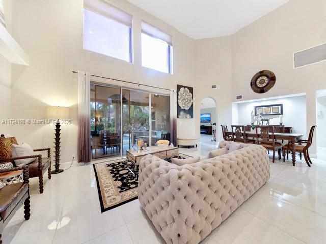 living room featuring light tile patterned flooring and a high ceiling