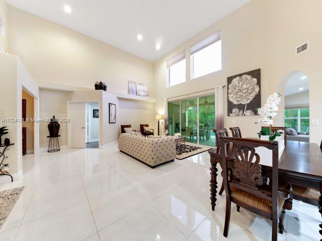 living room with a high ceiling, light tile patterned floors, and plenty of natural light