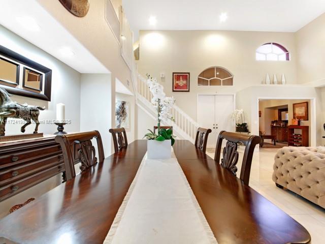 dining room with light tile patterned floors and a towering ceiling