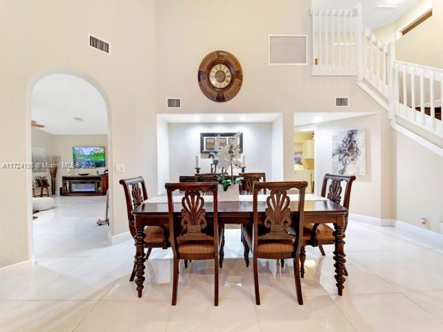 tiled dining room with a towering ceiling