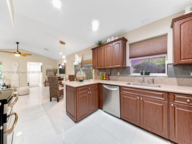 kitchen featuring ceiling fan, pendant lighting, stainless steel dishwasher, kitchen peninsula, and sink