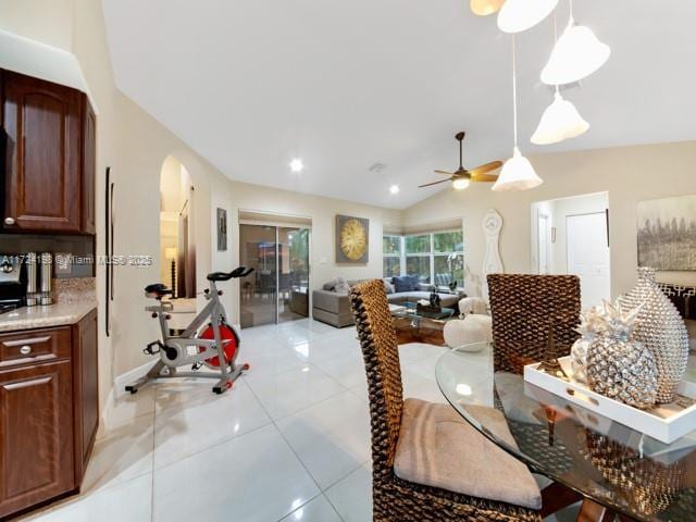 tiled dining space featuring vaulted ceiling and ceiling fan