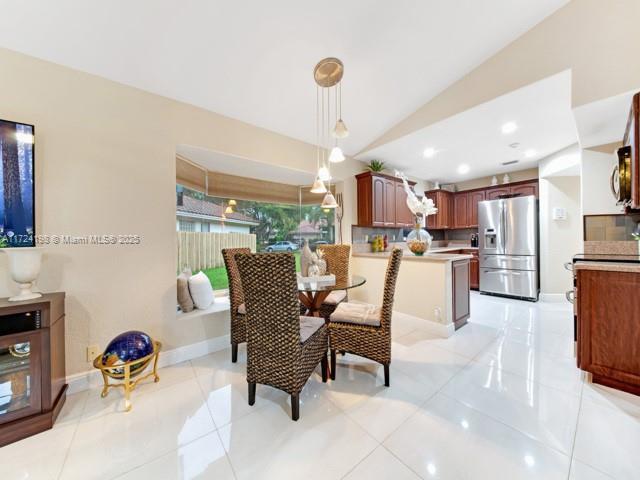 tiled dining space featuring lofted ceiling