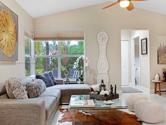 living room featuring vaulted ceiling and ceiling fan