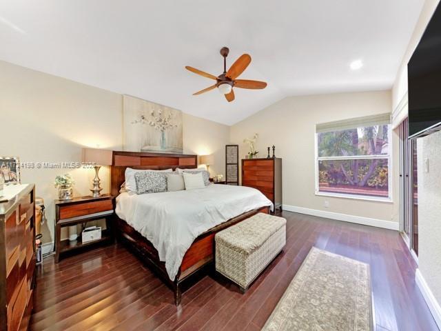 bedroom with ceiling fan, dark hardwood / wood-style floors, and lofted ceiling