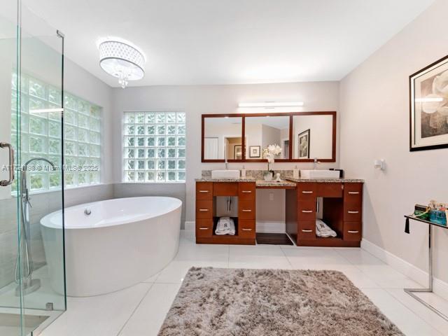 bathroom with tile patterned floors, separate shower and tub, and vanity