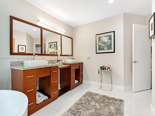 bathroom featuring vanity, a tub, and tile patterned floors