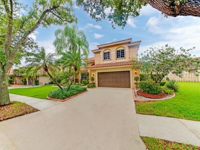 mediterranean / spanish house with a front lawn and a garage