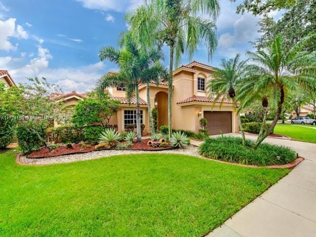 mediterranean / spanish-style house with a front yard and a garage