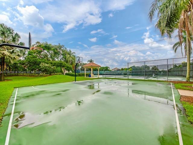 view of property's community with tennis court, a gazebo, a lawn, and basketball hoop