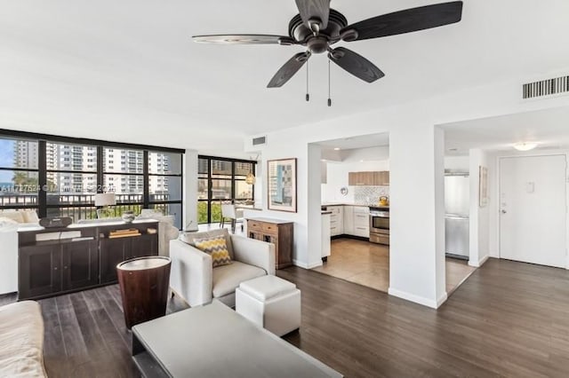 living room with ceiling fan, plenty of natural light, and dark hardwood / wood-style floors