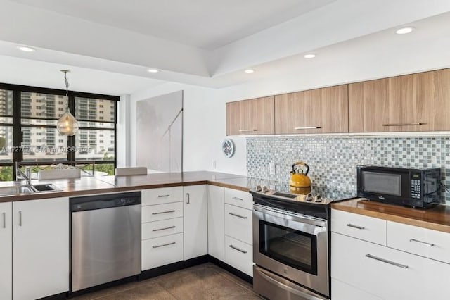 kitchen featuring stainless steel appliances, backsplash, decorative light fixtures, white cabinets, and sink