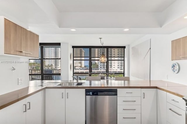 kitchen with white cabinetry, dishwasher, kitchen peninsula, and hanging light fixtures