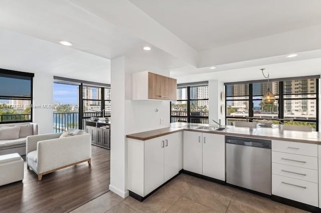 kitchen with pendant lighting, dishwasher, white cabinets, and sink