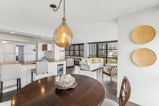 dining space featuring hardwood / wood-style flooring, expansive windows, and wine cooler