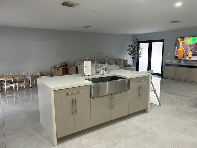 kitchen featuring sink, a kitchen island with sink, and french doors