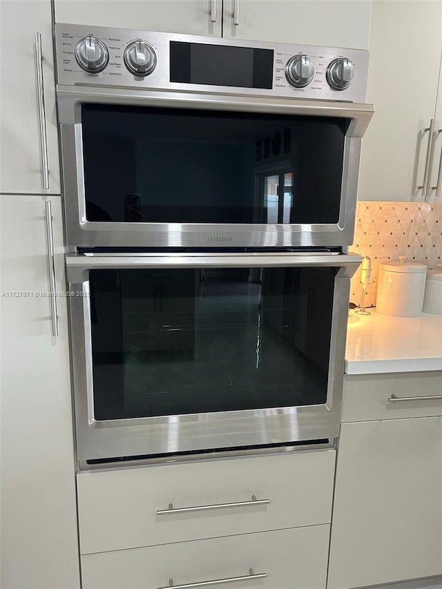 room details featuring white cabinetry and double oven