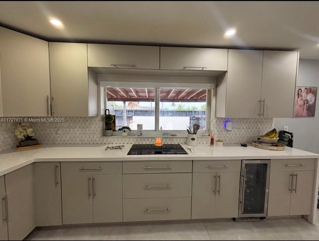 kitchen with light tile patterned floors, beverage cooler, decorative backsplash, and black electric cooktop