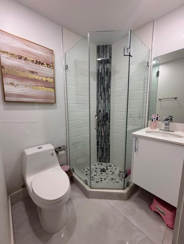 bathroom featuring a shower with door, toilet, and vanity