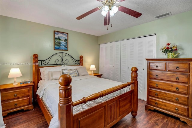 bedroom featuring dark wood-type flooring, ceiling fan, a closet, and a textured ceiling