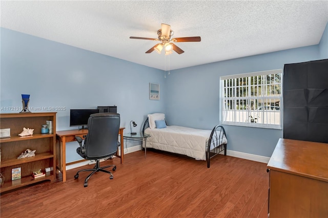 bedroom featuring hardwood / wood-style floors, a textured ceiling, and ceiling fan