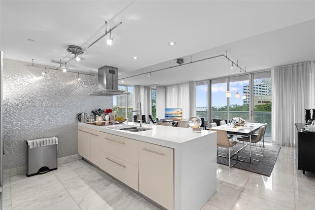 kitchen with sink, radiator heating unit, kitchen peninsula, island exhaust hood, and black electric stovetop