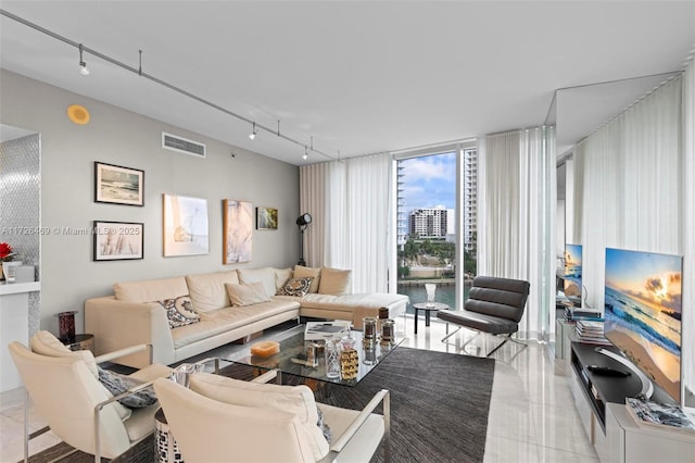 living room featuring light tile patterned flooring, a wall of windows, and rail lighting