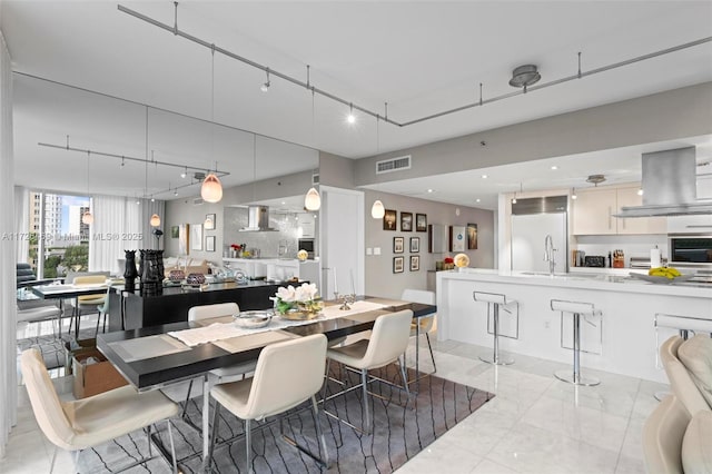 dining space featuring rail lighting and sink