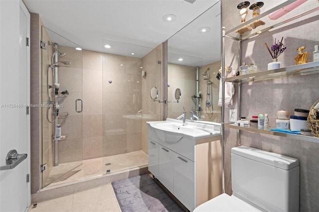 bathroom featuring vanity, tile patterned flooring, a shower with door, and toilet