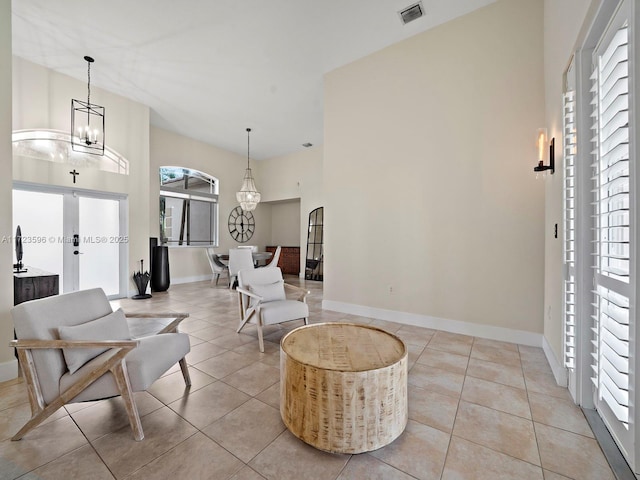 tiled foyer entrance featuring a wealth of natural light and a chandelier