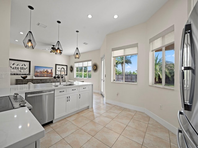 kitchen with decorative light fixtures, white cabinetry, stainless steel appliances, light tile patterned flooring, and ceiling fan