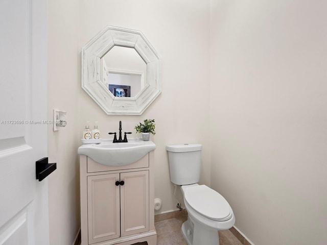 bathroom with toilet, vanity, and tile patterned floors