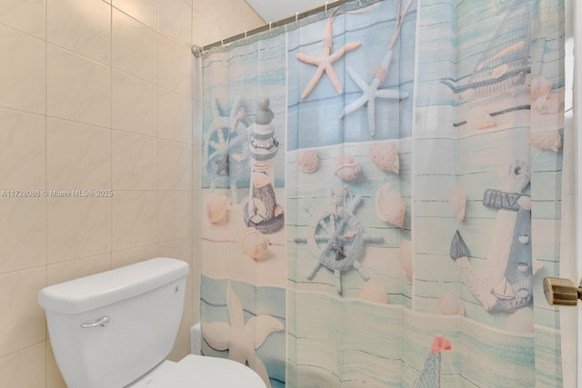 bathroom with tile walls, toilet, and a shower with curtain