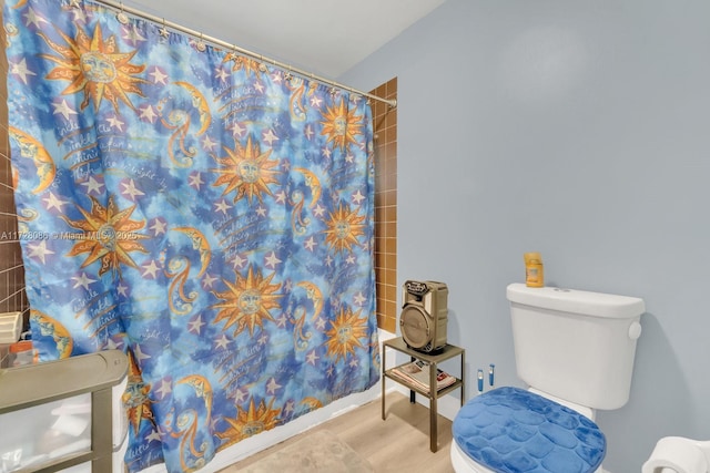 bathroom featuring toilet, hardwood / wood-style floors, and a shower with curtain