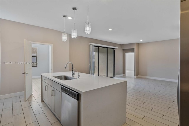 kitchen featuring pendant lighting, sink, light hardwood / wood-style flooring, dishwasher, and a kitchen island with sink