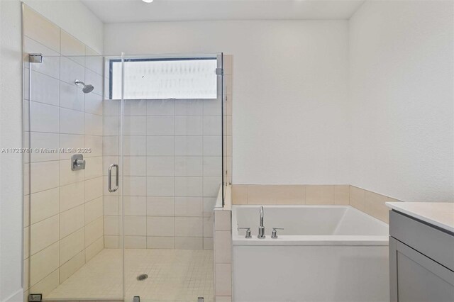 bathroom featuring vanity and independent shower and bath