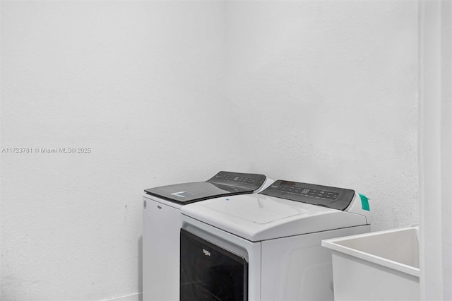 clothes washing area featuring sink and washing machine and dryer