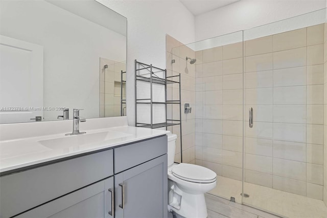 bathroom featuring vanity, an enclosed shower, and toilet