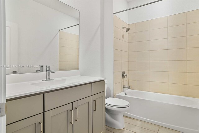 full bathroom featuring vanity, tiled shower / bath combo, and toilet