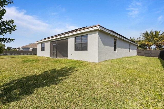 back of property featuring a lawn and a sunroom