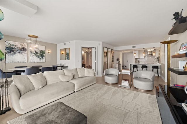 living room with an inviting chandelier and light hardwood / wood-style flooring